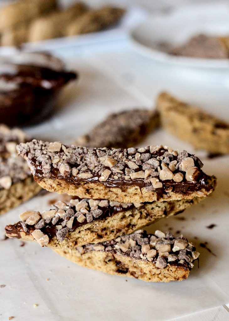 These Chocolate Dipped Toffee Biscotti are the perfect addition to your holiday cookie platter, and taste miles better than rock-hard store bought biscotti! | Recipe from Bakerita.com