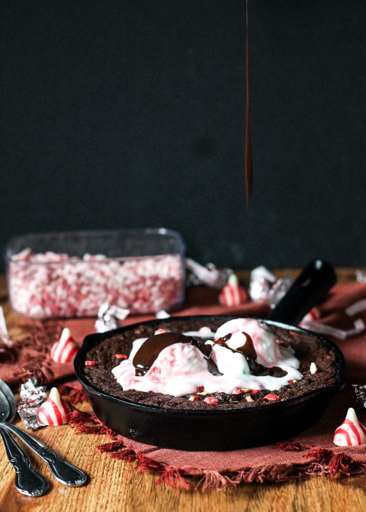 This Peppermint Skillet Brownie, loaded with chocolate, peppermint chips, and Candy Cane Kisses, is the perfect decadent treat to share with friends this winter! Best served warm with ice cream.