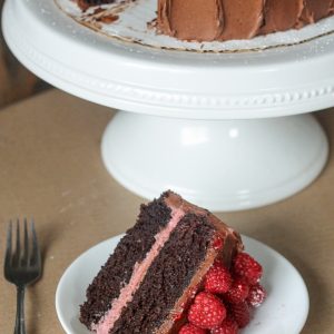 This Mocha Raspberry Cake has two layers of moist chocolate cake, a layer of sweet raspberry filling, frosted with a silky mocha buttercream and topped with fresh raspberries! This impressive cake is perfect for celebrating.