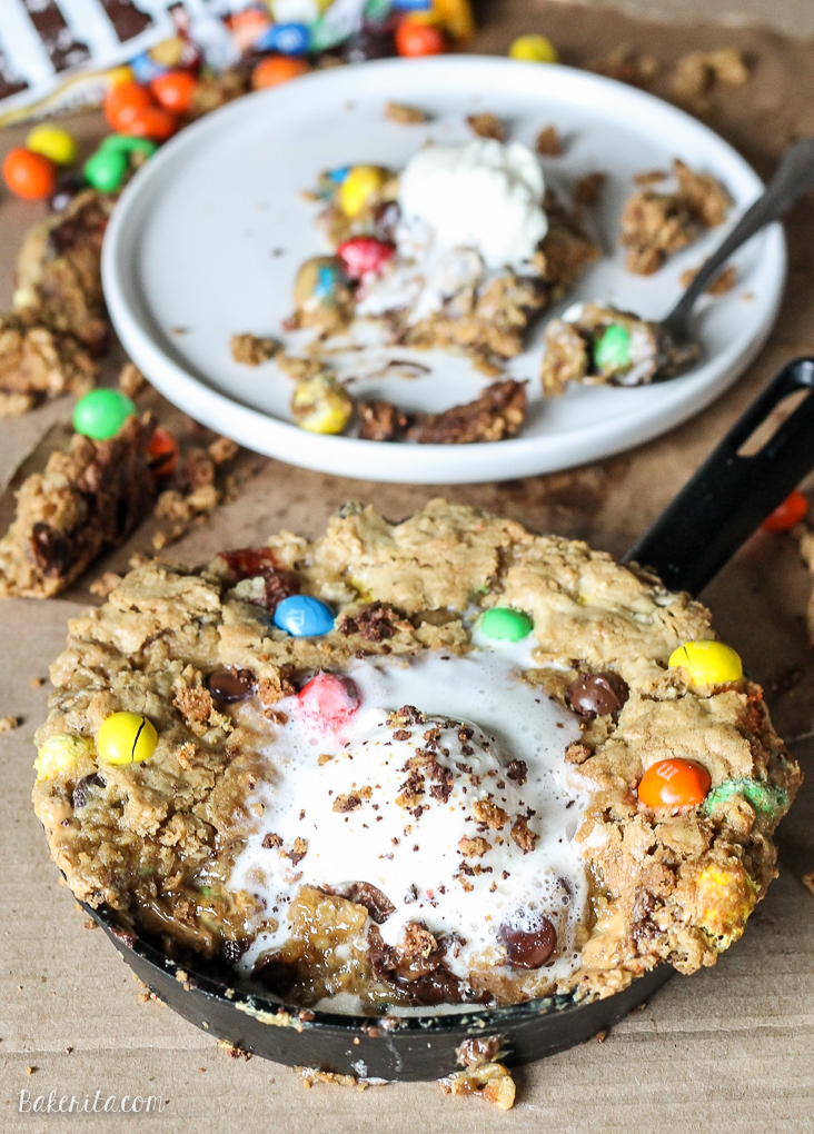 This Oatmeal M&M Peanut Butter Skillet Cookie is a quick and easy recipe made in one bowl that's perfect for sharing! It has a layer of peanut butter in the middle and lots of crispy edges. Top it with ice cream for a homemade version of the pizookie!