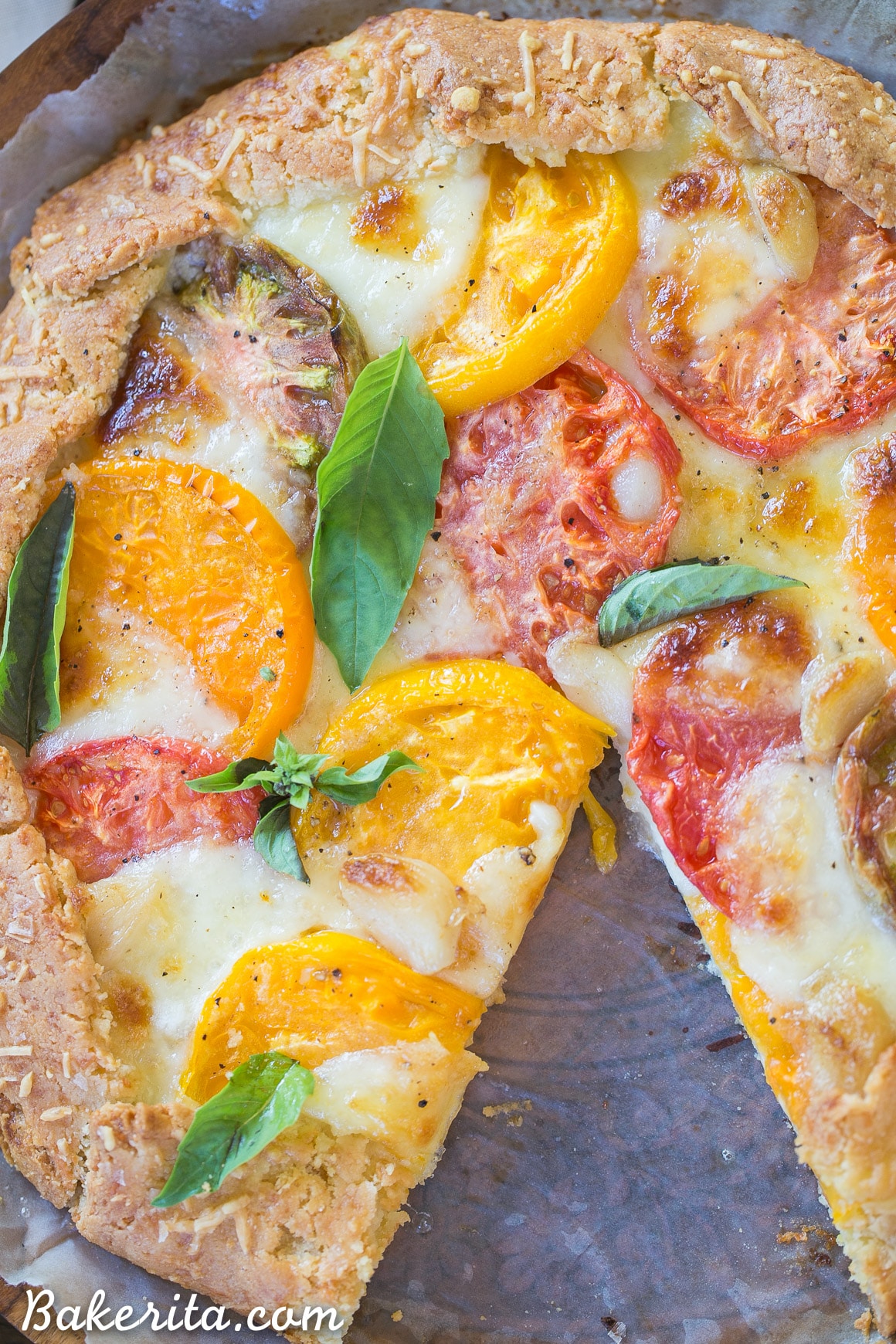 This Mozzarella Heirloom Tomato Galette showcases beautiful heirloom tomatoes bubbling with melted mozzarella cheese, all tucked into a gluten-free + grain-free Parmesan crust. 