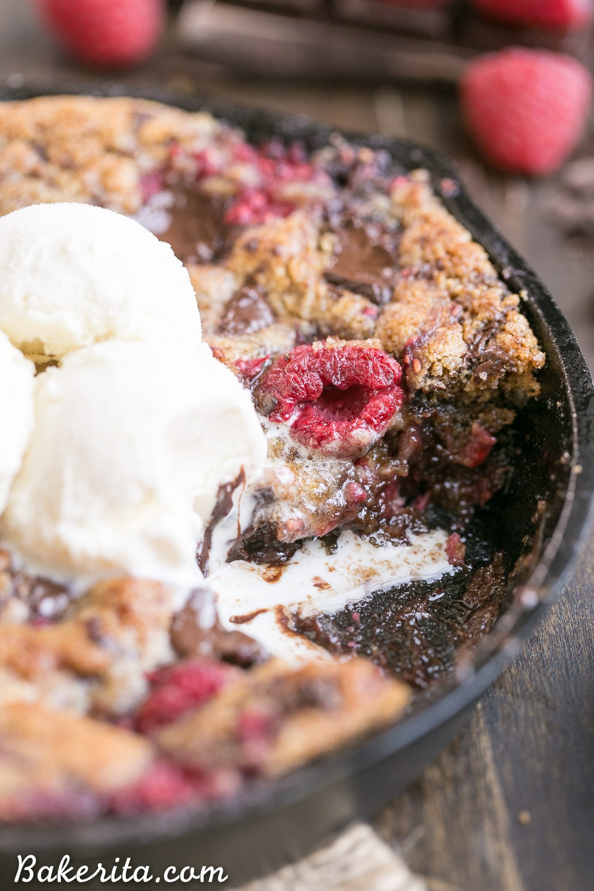 This Raspberry Chocolate Chunk Skillet Cookie is an easy, one bowl recipe loaded with fresh raspberries and dark chocolate chunks. This gooey skillet cookie is gluten-free, Paleo, and refined sugar free.