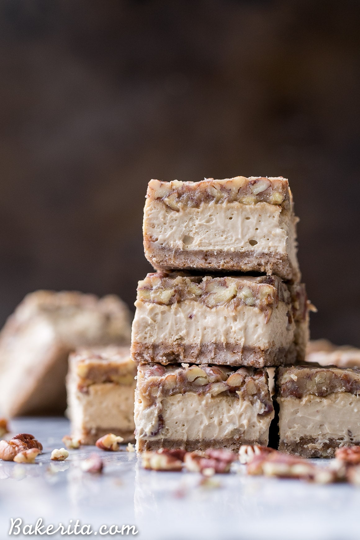 These Gluten Free Pecan Praline Cheesecake Bars will be your new favorite dessert! The super creamy cheesecake filling has a sweet + crunchy pecan praline topping.