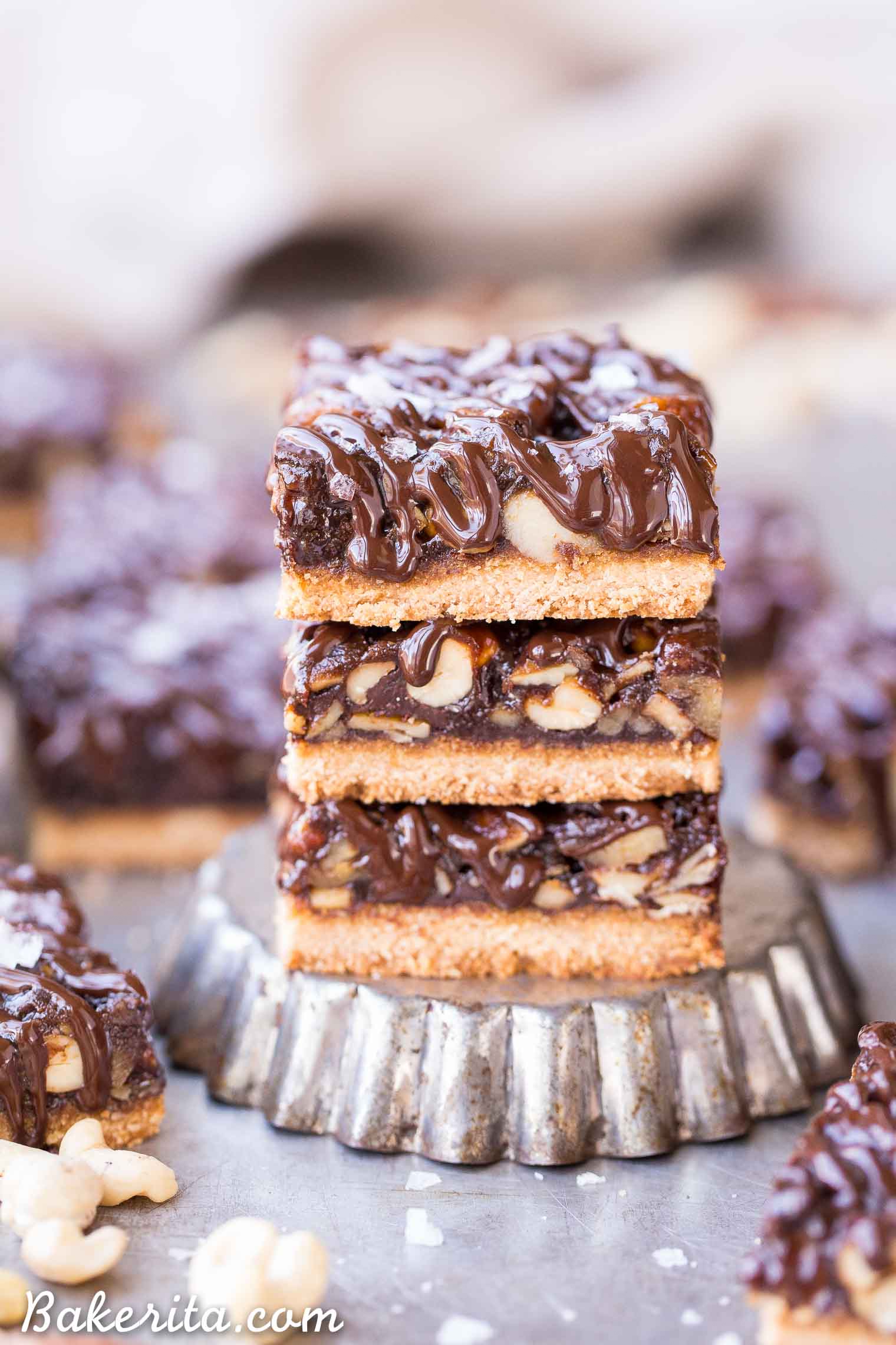 These Salted Chocolate Mixed Nut Bars are a scrumptious dessert bar that has a gooey, nutty center on top of a shortbread crust, topped with dark chocolate and flaky sea salt. These gluten free, paleo, and vegan bars are an irresistible way to satisfy your sweet tooth.
