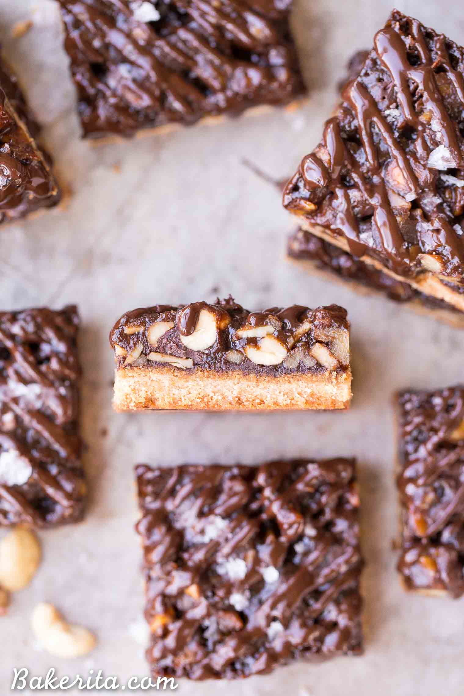 These Salted Chocolate Mixed Nut Bars are a scrumptious dessert bar that has a gooey, nutty center on top of a shortbread crust, topped with dark chocolate and flaky sea salt. These gluten free, paleo, and vegan bars are an irresistible way to satisfy your sweet tooth.