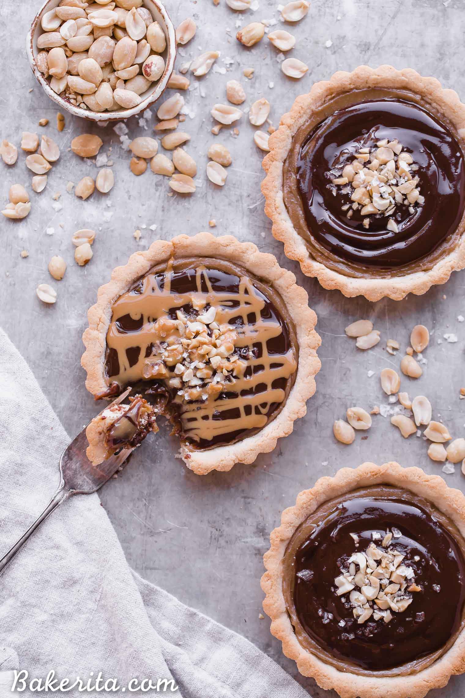 These Chocolate Peanut Butter Caramel Tarts have a crunchy shortbread crust that's filled with a creamy peanut butter date caramel and topped with creamy chocolate ganache! This decadent tart recipe is gluten-free, grain-free and vegan.