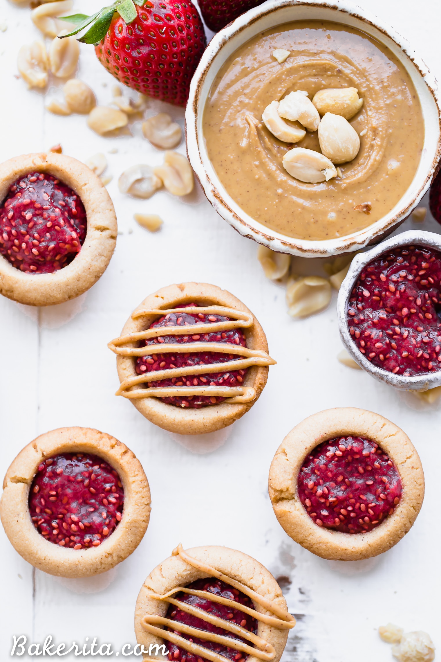 These Peanut Butter & Jelly Tartlets are made with just SEVEN ingredients! They have a crunchy peanut butter cookie crust, filled with an easy strawberry chia jam and topped with even more peanut butter. These gluten-free, grain-free, and vegan tartlets are as cute as they are delicious!