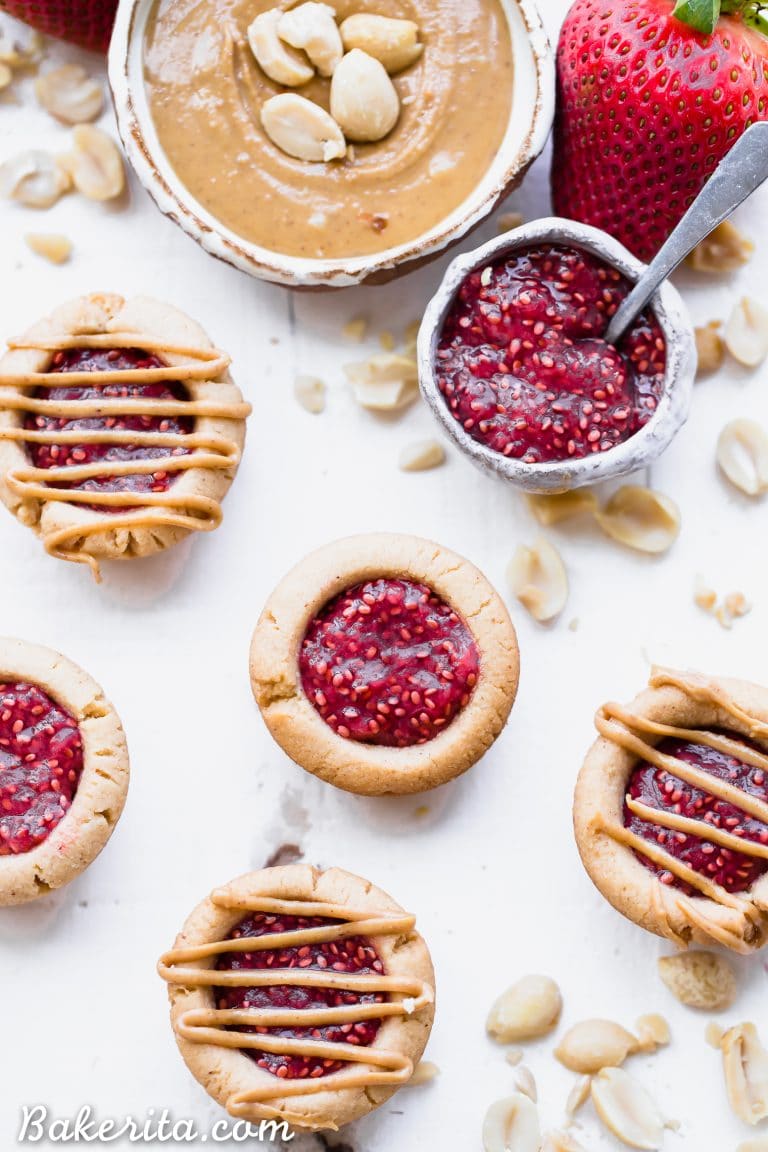 These Peanut Butter & Jelly Tartlets are made with just SEVEN ingredients! They have a crunchy peanut butter cookie crust, filled with an easy strawberry chia jam and topped with even more peanut butter. These gluten-free, grain-free, and vegan tartlets are as cute as they are delicious!