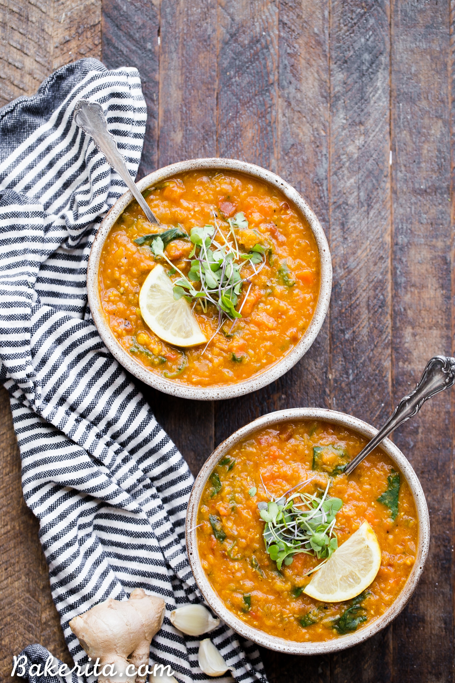 Two bowls of Vegan Red Lentil Soup topped with microgreens and a lemon wedge! The perfect healthy vegan dinner.