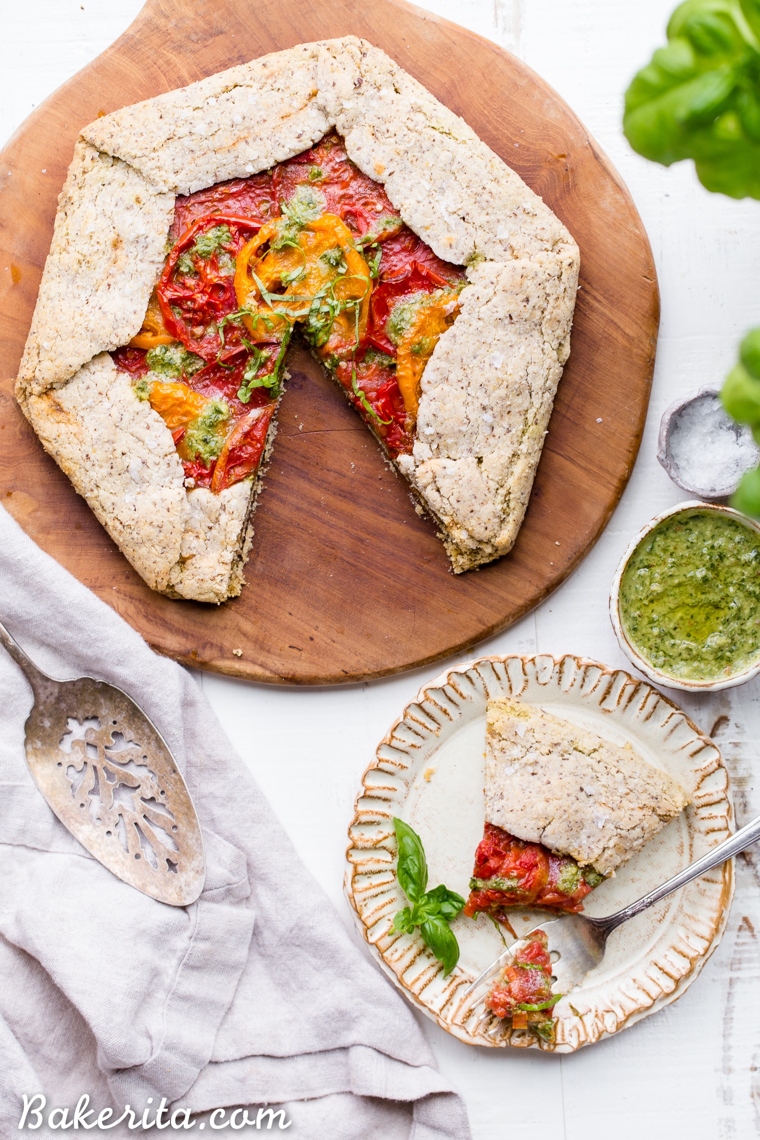 This Pesto + Heirloom Tomato Galette has an incredibly flaky, savory crust filled with homemade pesto and thick slices of heirloom tomatoes. Served warm, it's a truly delicious appetizer or meal that you'd never guess is gluten-free, paleo, and vegan.