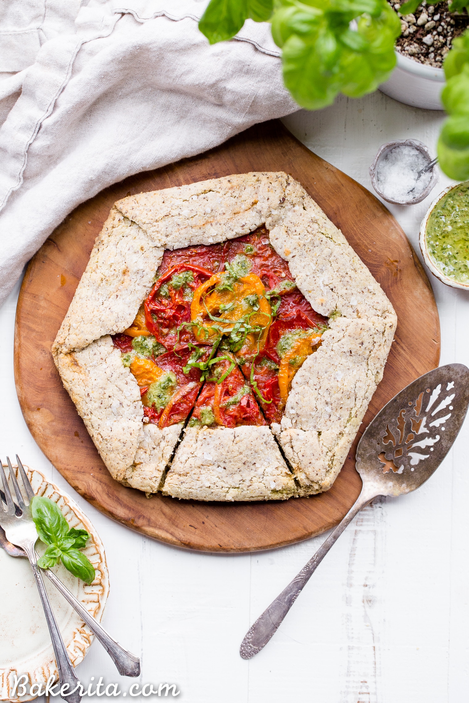 This Pesto + Heirloom Tomato Galette has an incredibly flaky, savory crust filled with homemade pesto and thick slices of heirloom tomatoes. Served warm, it's a truly delicious appetizer or meal that you'd never guess is gluten-free, paleo, and vegan.