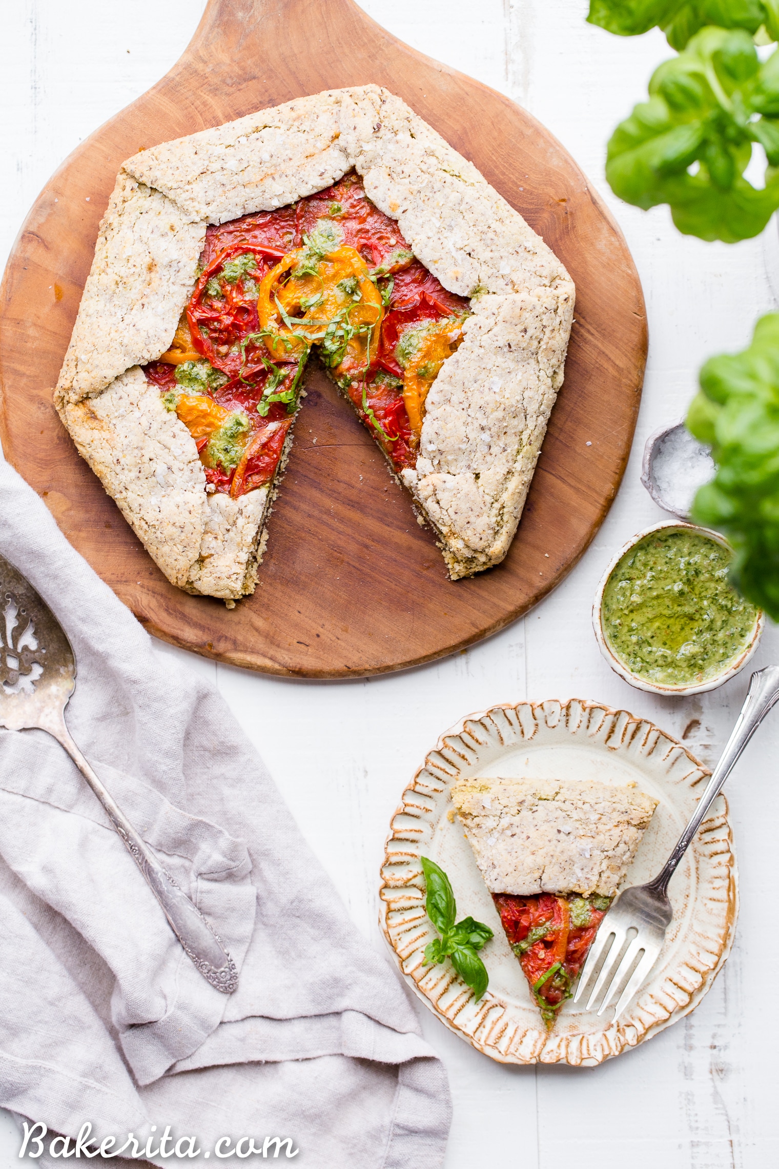 This Pesto + Heirloom Tomato Galette has an incredibly flaky, savory crust filled with homemade pesto and thick slices of heirloom tomatoes. Served warm, it's a truly delicious appetizer or meal that you'd never guess is gluten-free, paleo, and vegan.