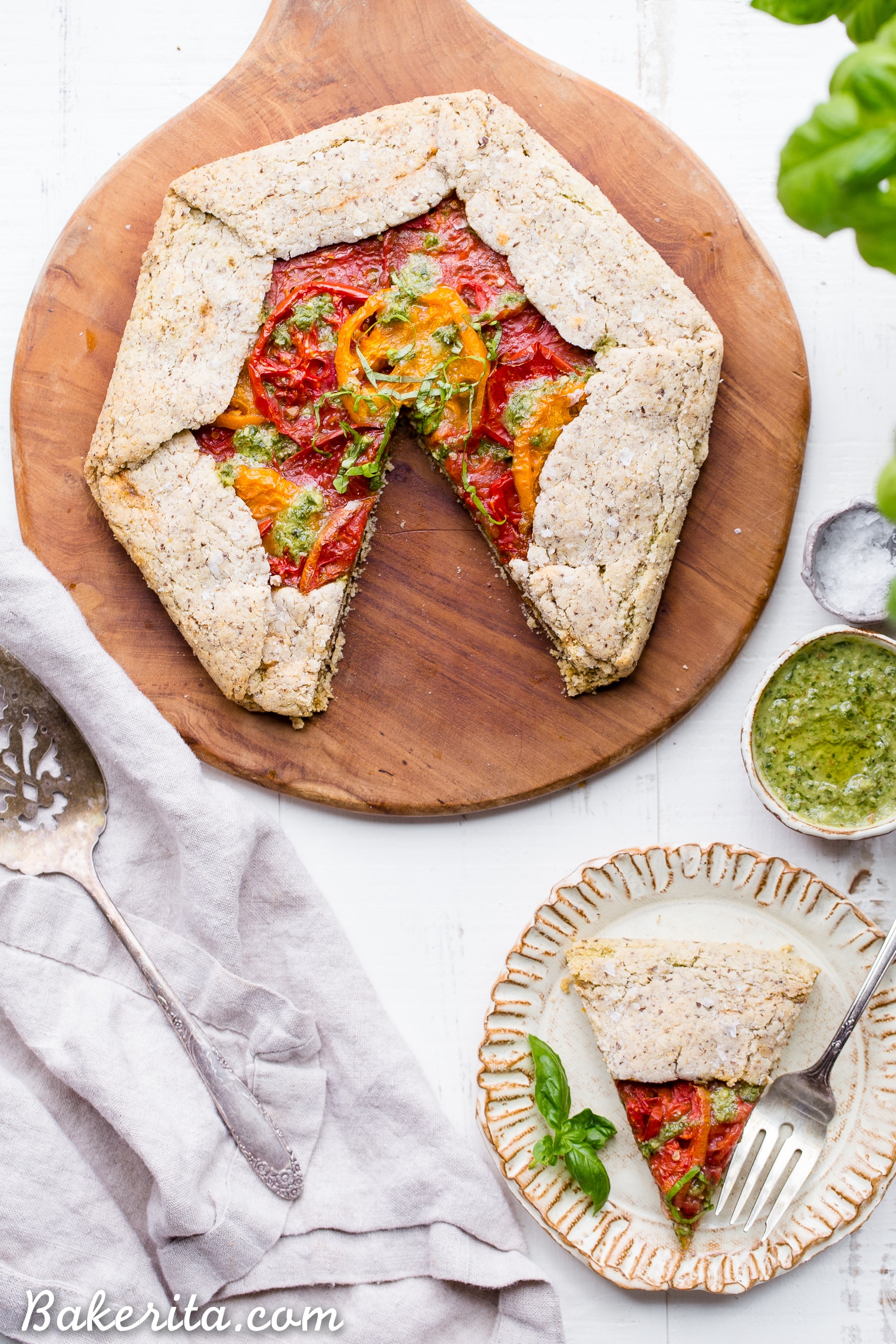 This Pesto + Heirloom Tomato Galette has an incredibly flaky, savory crust filled with homemade pesto and thick slices of heirloom tomatoes. Served warm, it's a truly delicious appetizer or meal that you'd never guess is gluten-free, paleo, and vegan.