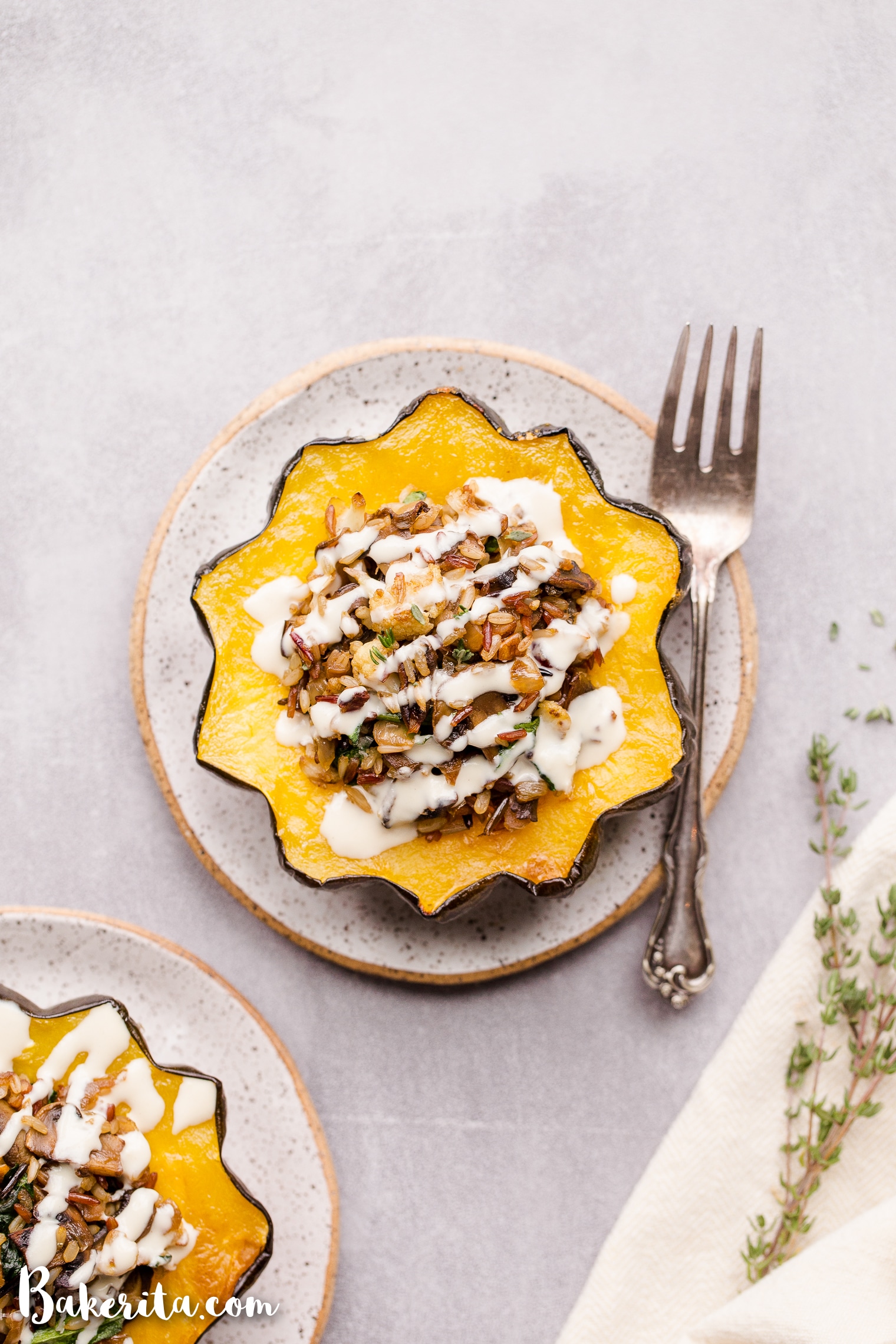 This Mushroom & Wild Rice Stuffed Acorn Squash is filled with caramelized onions, cauliflower florets, spinach, dried cranberries, and pecans. It's served with a drizzle of lemon tahini sauce. This comforting and colorful dish has a variety of texture, tons of flavor, and makes the perfect hearty dinner or side dish.
