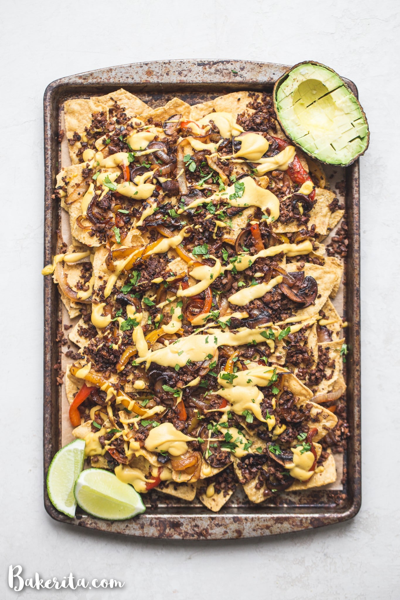 These are the BEST Vegan Nachos I've ever had! They're loaded with sauteed vegetables, vegan taco meat, pico de gallo, avocado, cilantro, and topped with a ton of vegan cheese sauce. They're the perfect cheesy snack for game day.